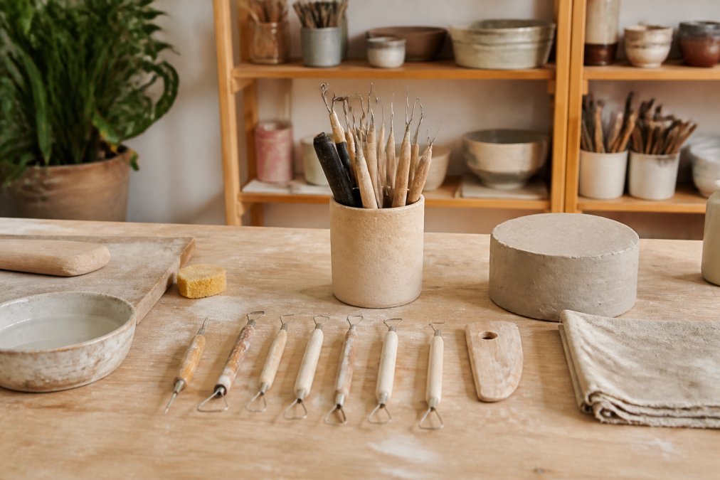 Organized pottery studio storage with clean tools arranged on a wooden shelf, demonstrating proper tool maintenance and organization with natural studio lighting