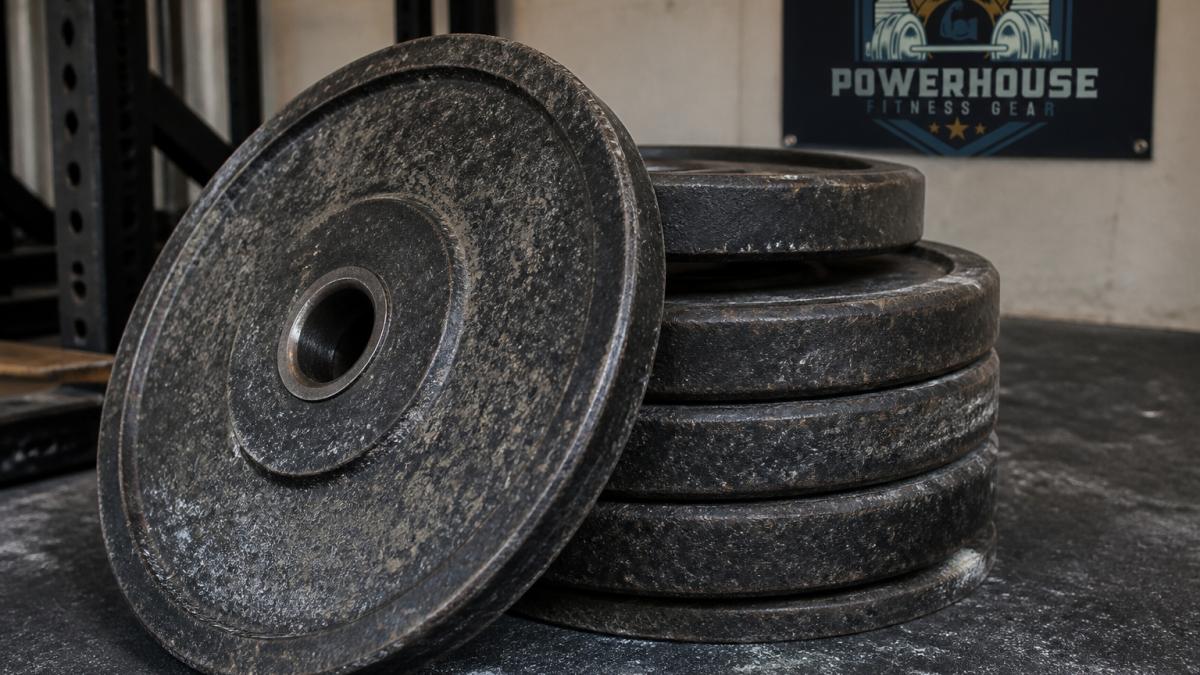 Infographic comparing the material properties and wear patterns of durable weight plates for home gyms