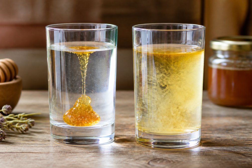 Zwei Gläser nebeneinander - links echten Honig im Wasser (sinkt langsam, bleibt zusammenhängend), rechts gepanschten Honig (vermischt sich schnell)