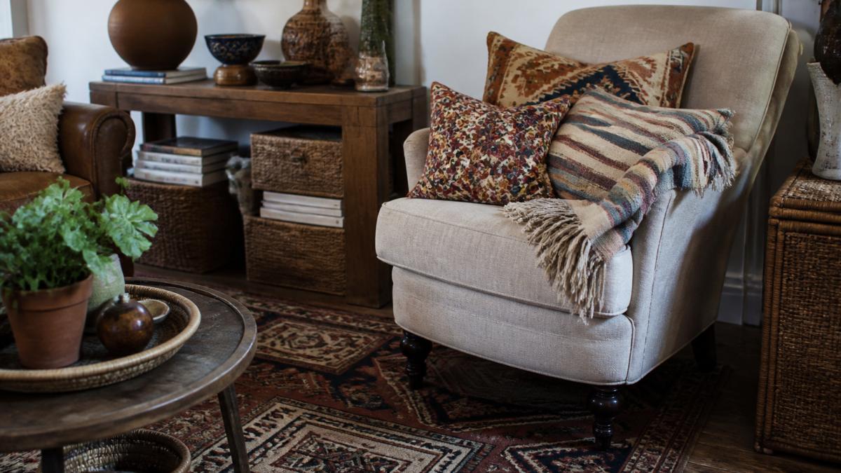 Cozy corner with mixed patterned throw pillows, vintage geometric rug, and a layered bohemian upholstered chair
