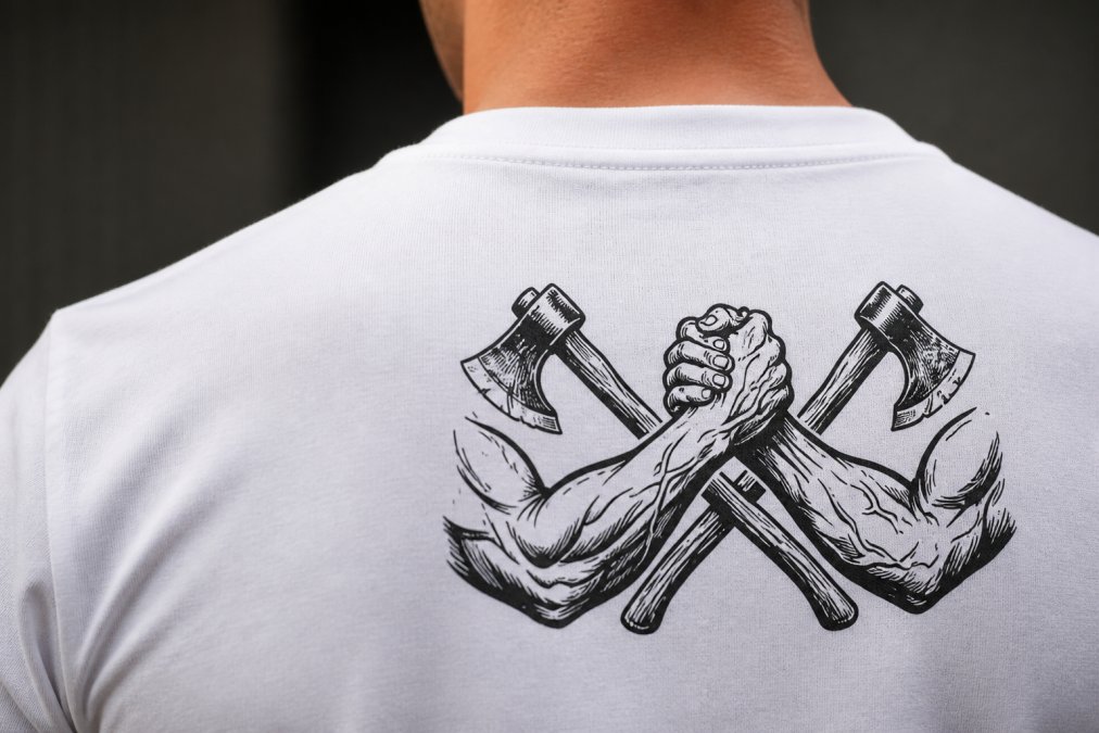 Close-up detail of subtle cross design integrated into t-shirt weave, showing how faith-inspired messaging appears understated and sophisticated without overwhelming the overall aesthetic