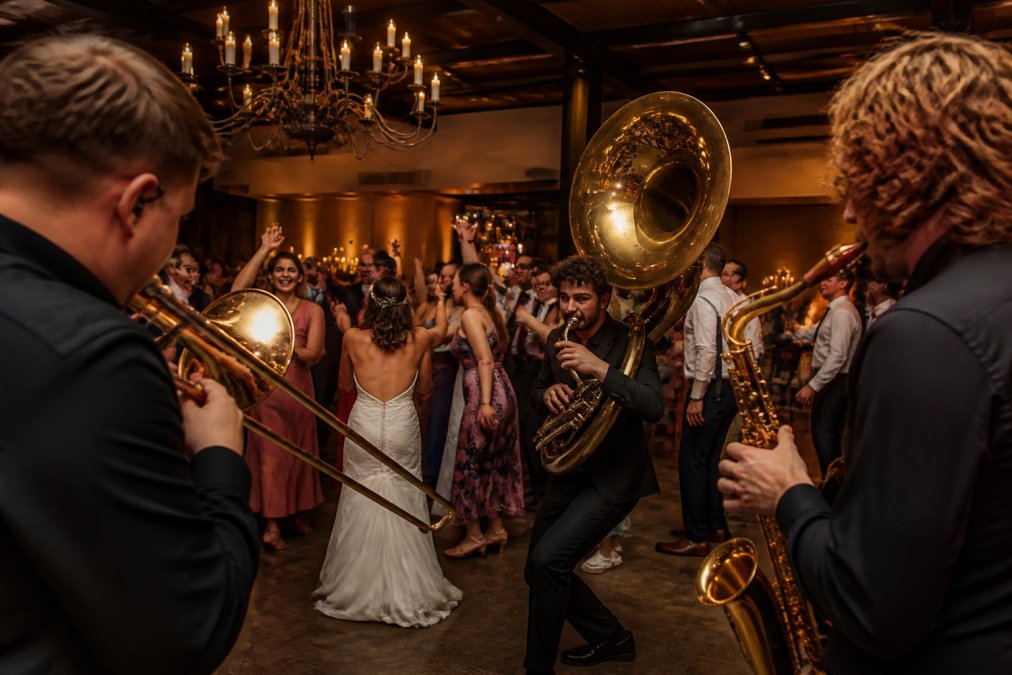 Live muzikanten treden op tijdens een bruiloftsfeest met een entertainment pakket voor dansende en lachende gasten.
