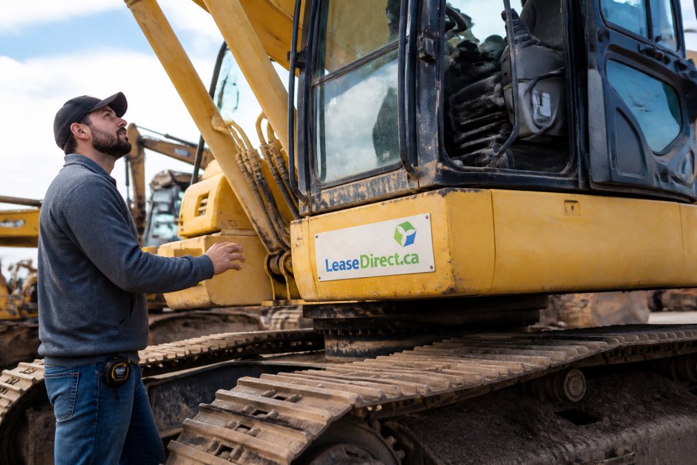 Small business owner inspecting used equipment on job site, examining machinery with confidence and natural daylight