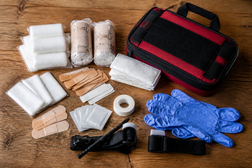 Infographic displaying essential first aid supplies for bug out bags including bandages, tourniquets, and medical gear.