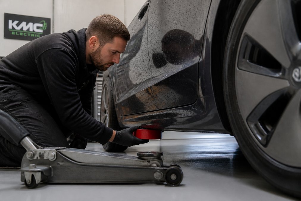 Red rubber jacking puck positioned under a Tesla Model 3 for a DIY lift
