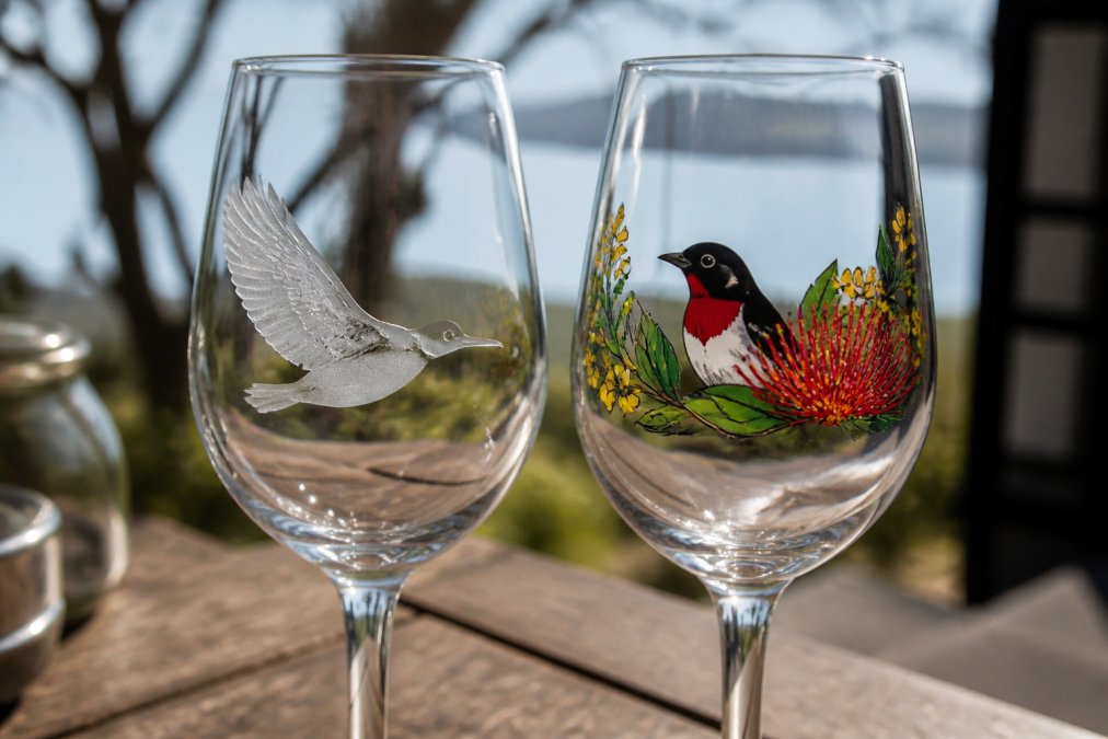 Close-up of etched wine glass showing frosted textured surface and depth alongside printed wine glass with vibrant colour branding, both displayed in natural daylight to highlight surface finish differences