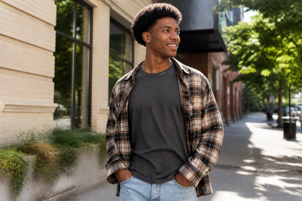 Young adult wearing a faith-based graphic tee and flannel for evangelism fashion on a city sidewalk