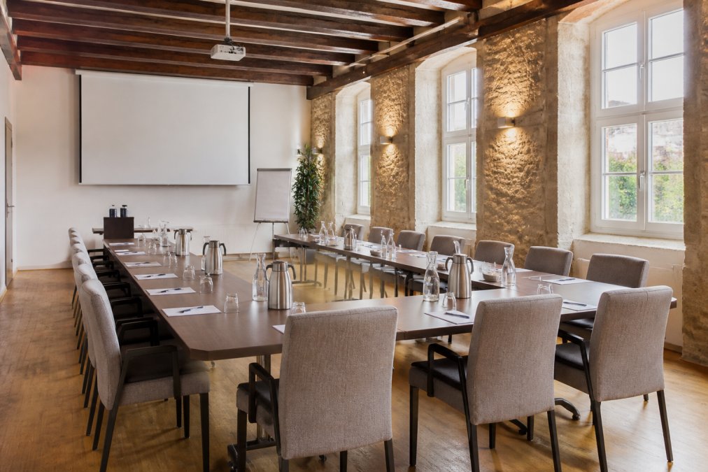 Heller Tagungsraum im Weingut als Eventlocation für Firmen in Rheinhessen mit U-Form-Bestuhlung und Technik.