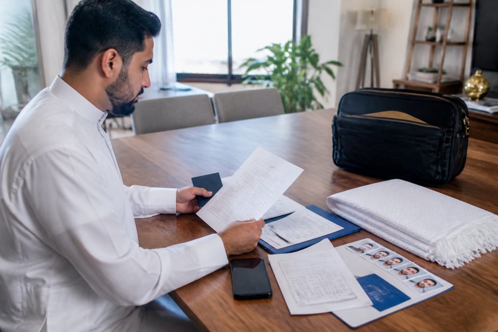 Un pèlerin prépare ses documents pour éviter un refus inscription nusuk sur son ordinateur portable.