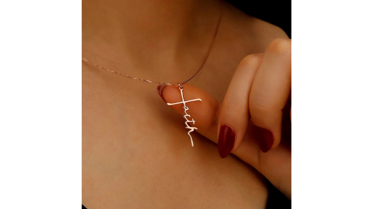 Flat lay of several gold cross pendants including a minimalist design and a zirconia-studded cross on a linen cloth