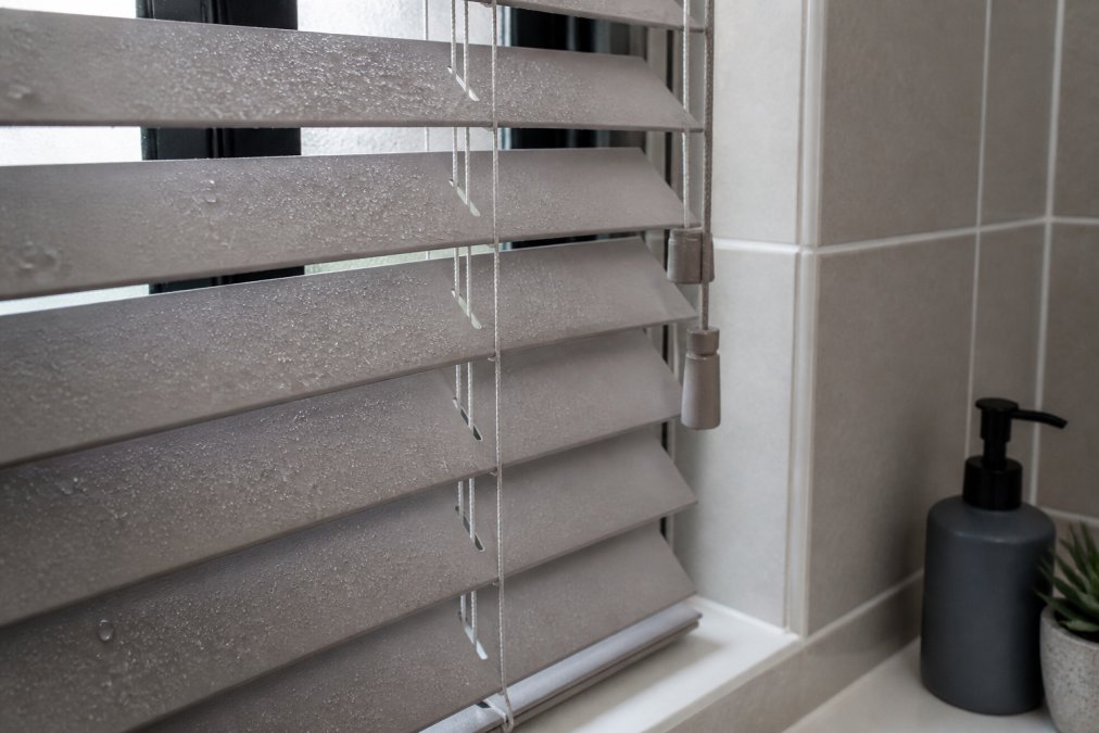 Professional illustration showing faux wood vs real wood blinds