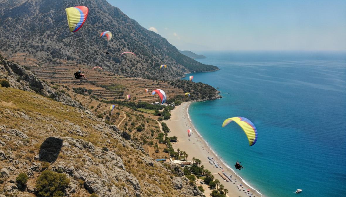 Gülümseyen tandem yamaç paraşütü pilotu ve yolcusunun tam ekipmanla kask ve harness takılı halde Babadağ kalkış rampasında hazırlanırken çekilmiş fotoğrafı; arkalarında panoramik dağ ve deniz manzarası uzanıyor, sabah güneşi ışıkları ekipmanları aydınlatıyor