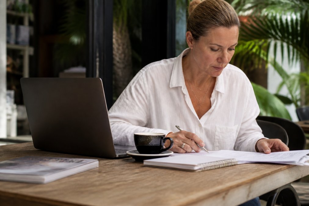 A business consultant reviewing financial documents for financial instability coaching at a desk.