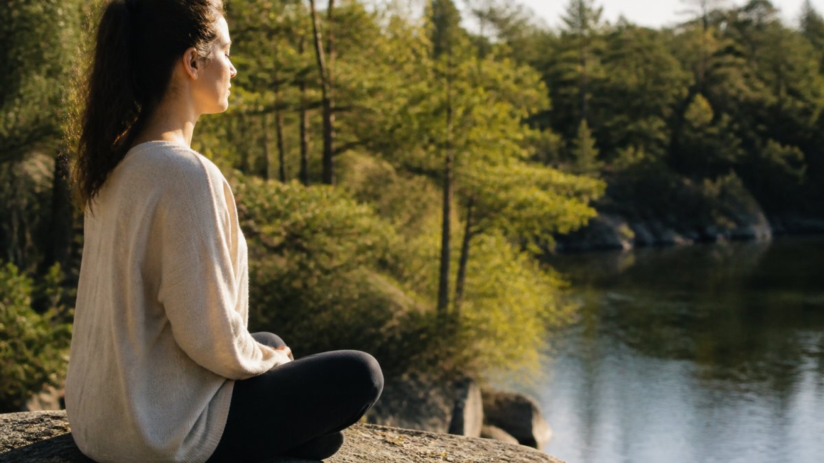 Find Clarity During Major Life Transitions 1 Person sitting peacefully outdoors in natural light with hands resting in their lap during a moment of reflection