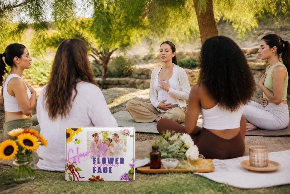 Small group of women in a peaceful garden setting with soft natural lighting, sitting in a circle during a guided mindfulness meditation session led by a calm, centered instructor wearing neutral tones