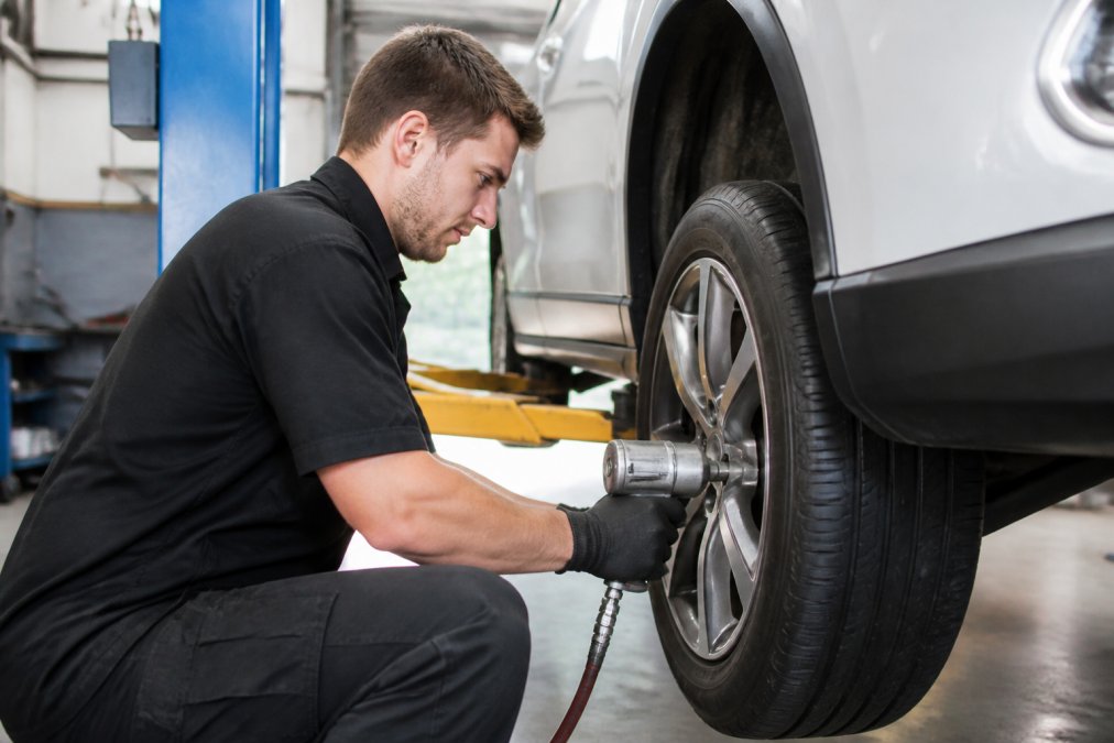Certified technician using professional equipment to install a tire, relevant to a firestone vs midtown tire comparison.