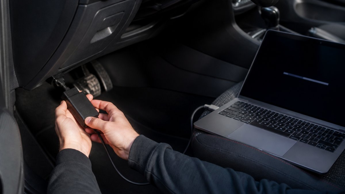 Step-by-step process of connecting an OBD diagnostic tool to a vehicle port for ECU software flashing