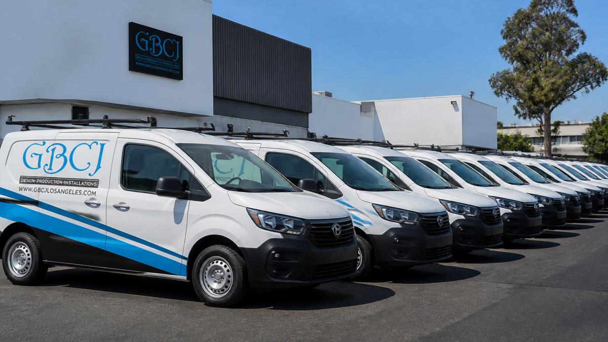 A row of service vehicles showcasing fleet branding consistency with matching logos and contact details.