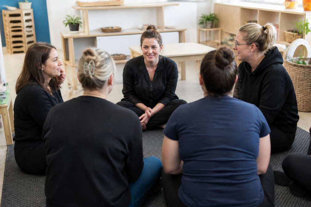 Early learning educators sitting in a circle to foster shared accountability during an open staff meeting