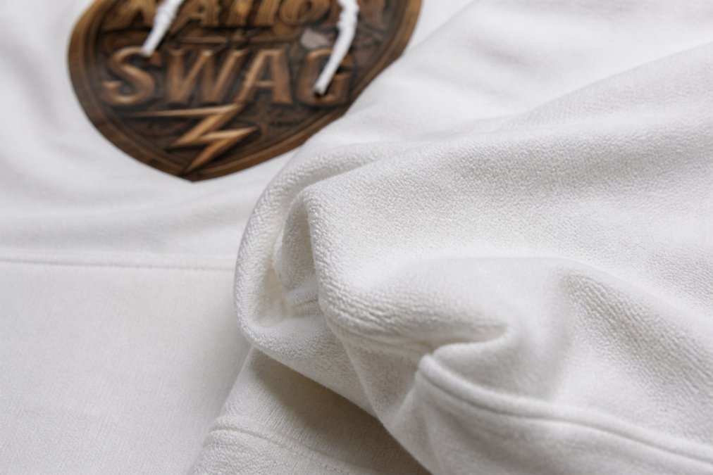 Close-up of heavy-weight hoodie fabric showing detailed texture of cotton-polyester blend weave with visible air jet yarn fibers creating soft surface, natural studio lighting