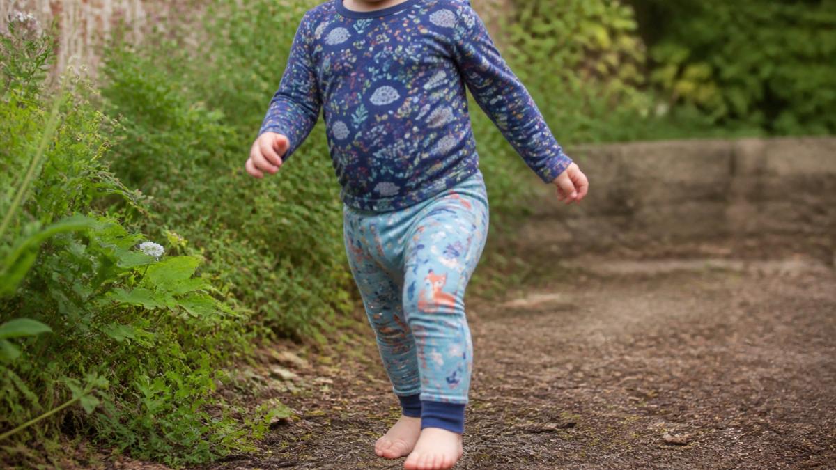 Close-up of a toddler wearing well-fitted baby leggings and a coordinating top, showing comfortable movement and proper garment fit around the waist and ankles in natural daylight