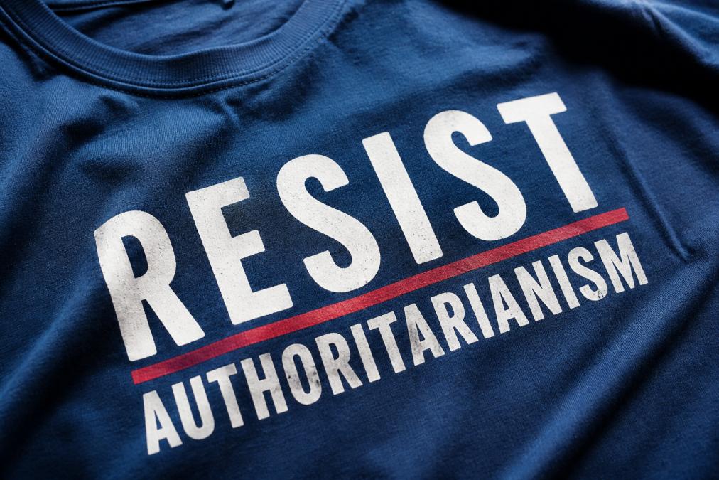 Close-up of a screen-printed political slogan on a cotton t-shirt, showing crisp text and color detail