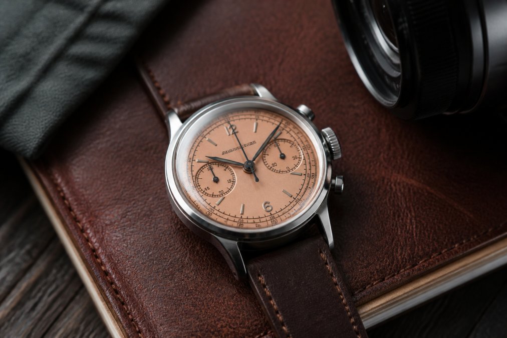 Vintage-inspired chronograph with a salmon sector dial reflecting the elegant Furlan Marri style on a leather notebook.