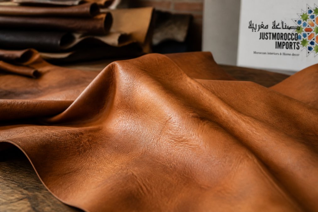 Close-up macro photograph showing genuine vegetable-tanned goat leather with natural texture variations, subtle grain patterns, and surface character marks from traditional hand-crafting techniques