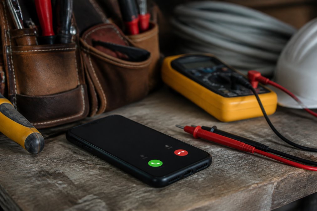 Smartphone notification on a workbench visualizing automated electrical service leads capture process