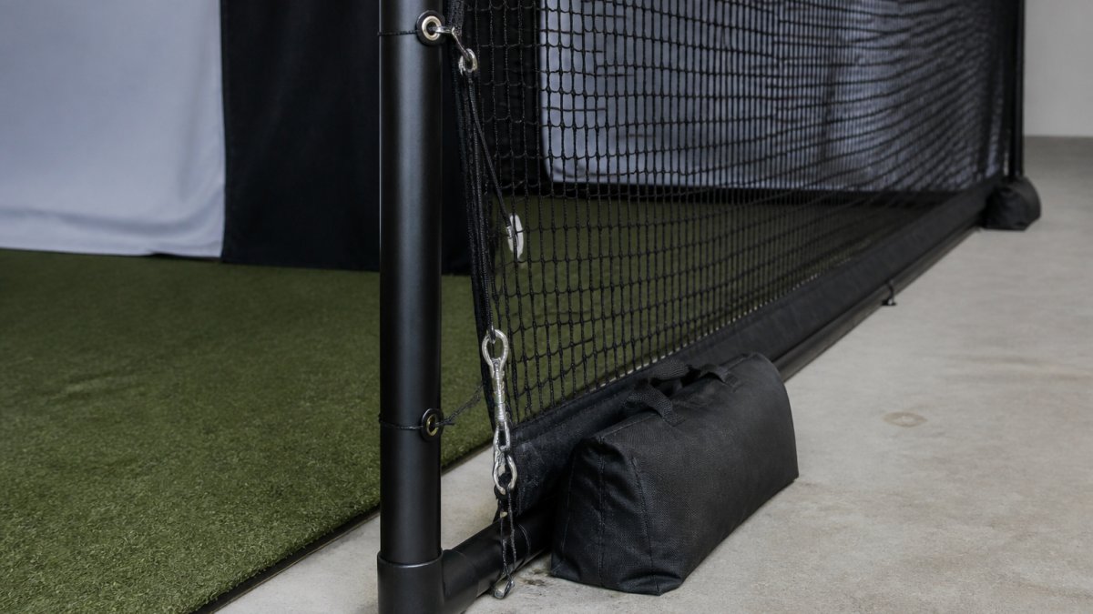 Diagram showing the attachment points for side netting and weighted base stabilization on a simulator frame.