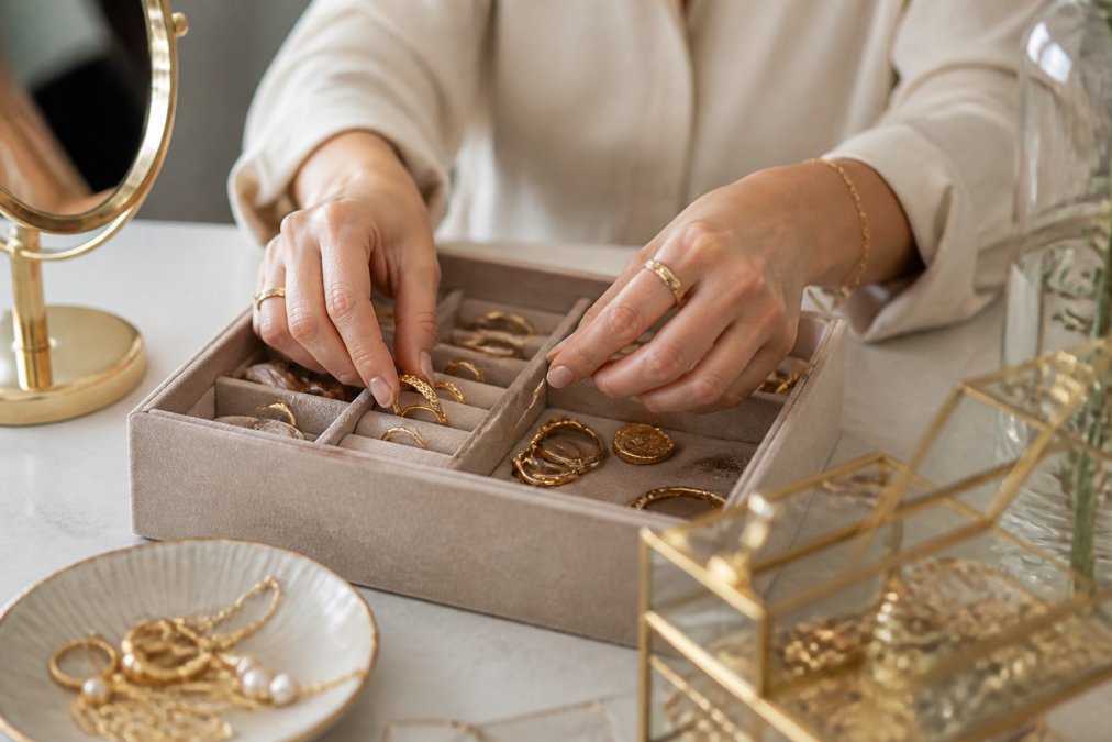 Elegante gouden sieraden netjes opgeborgen in een zachte suède sieradendoos met individuele vakken, zachte stof bescherming zichtbaar