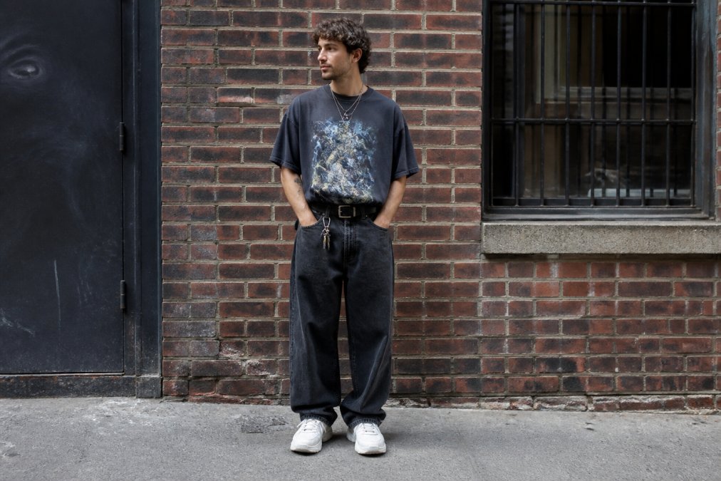 Man wearing an oversized graphic tee and baggy denim for modern graphic tee styling in an urban setting