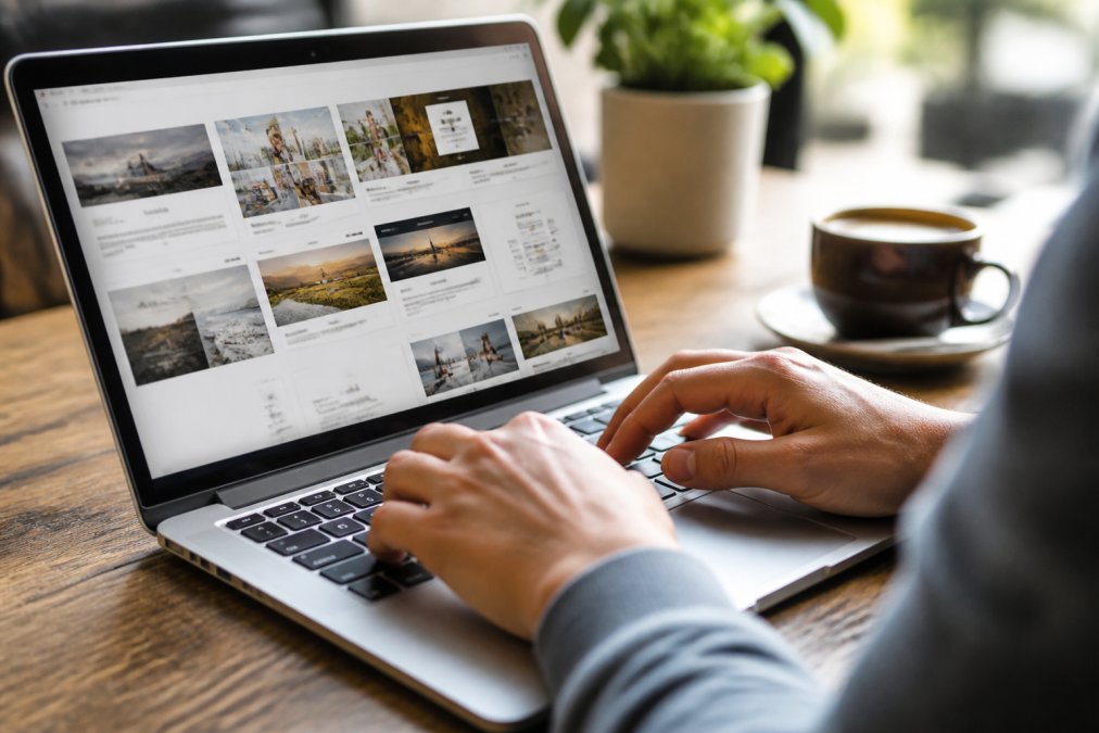 Close-up van handen die op een toetsenbord typen terwijl een websitetemplate op de achtergrond zichtbaar is op het scherm