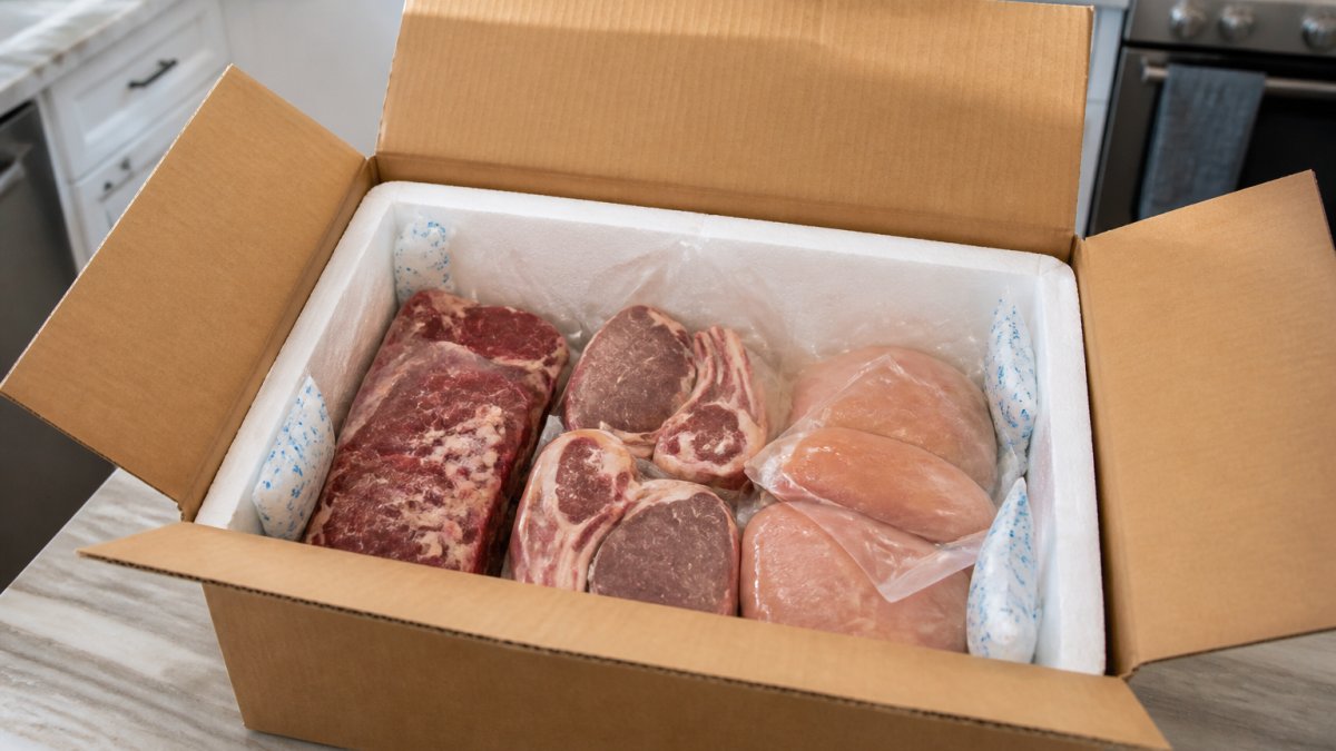 An opened halal meat subscription box displaying fresh cuts of beef, lamb, and chicken neatly packaged with ice packs and insulation, ready for delivery to a home