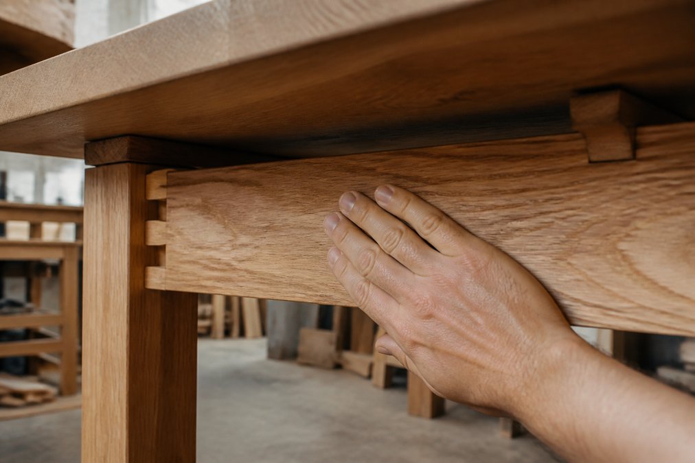 Diagram comparing solid oak dovetail joints and particle board for furniture durability