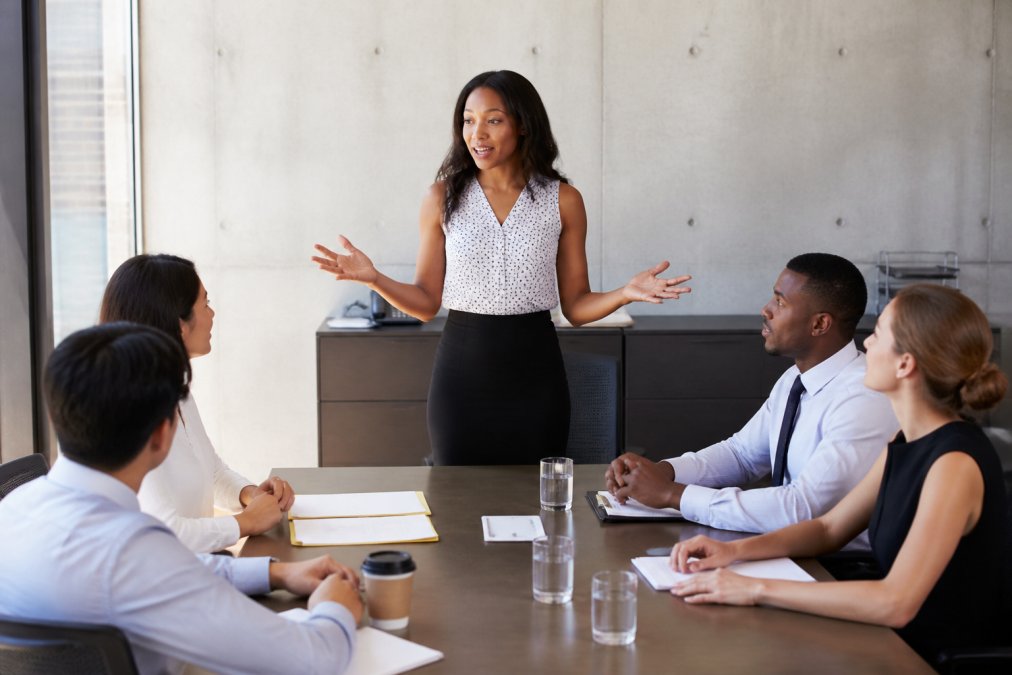 Visual roadmap for Facilitator addressing a diverse group of workshop participants seated around a conference table,...