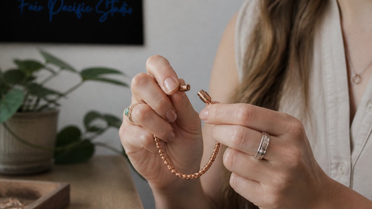 Close-up of a woman's hands fastening a delicate copper bracelet with a magnetic clasp, soft natural light, neutral background, focus on the clasp mechanism and ease of use