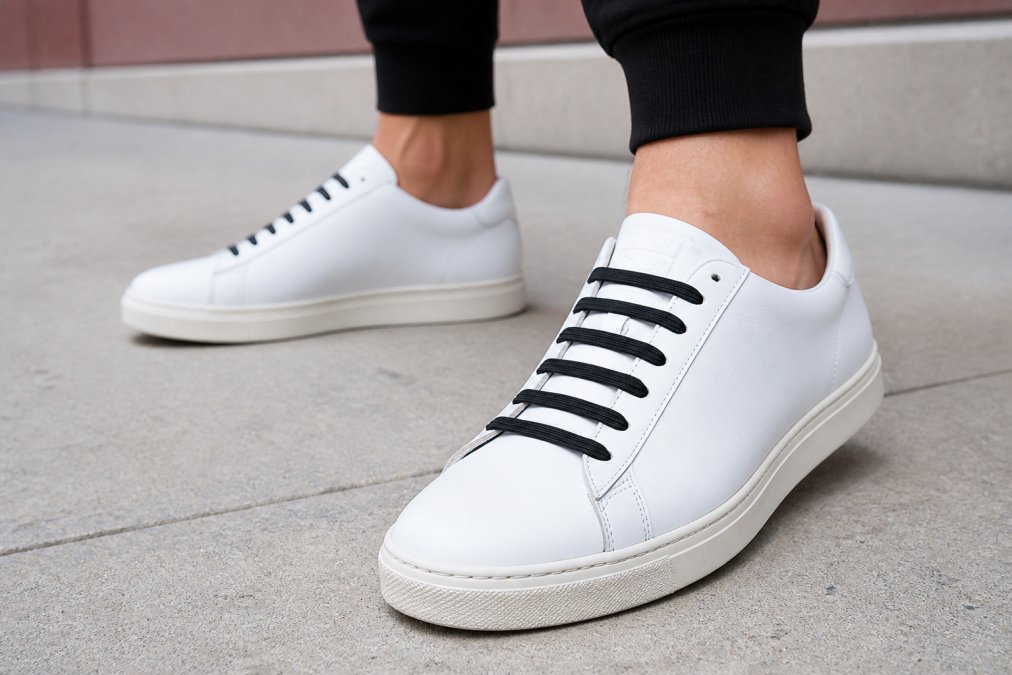 Person easily slipping on a wide sneaker with elastic no-tie laces installed, demonstrating the smooth motion and secure fit without any hand adjustments needed