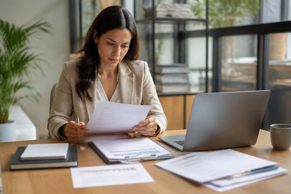Professional reviewing documents at a desk while using a fractional cmo checklist to evaluate candidates