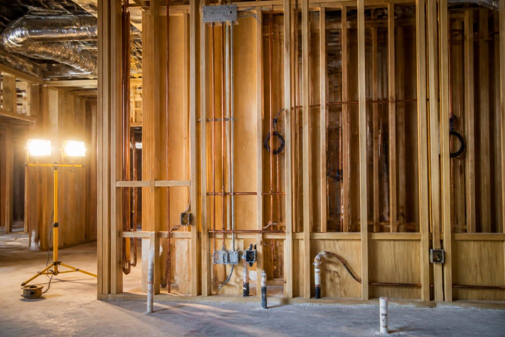 Exposed plumbing and electrical conduits installed by a dental practice contractor in an unfinished office.