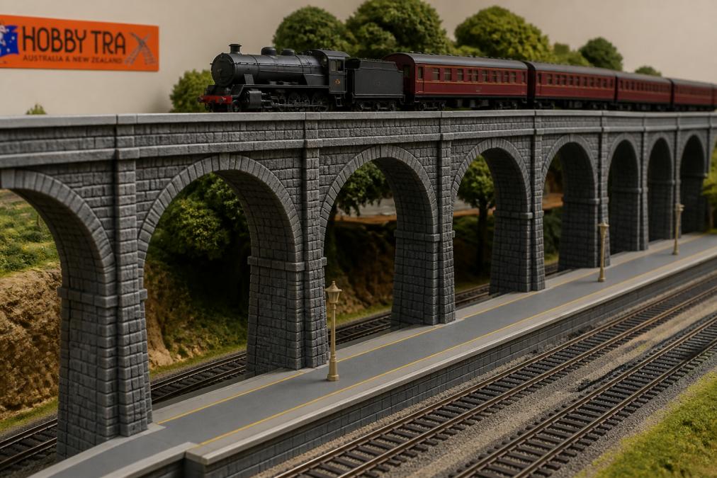 HO scale locomotive crossing a modular model railway viaduct with platform scenery