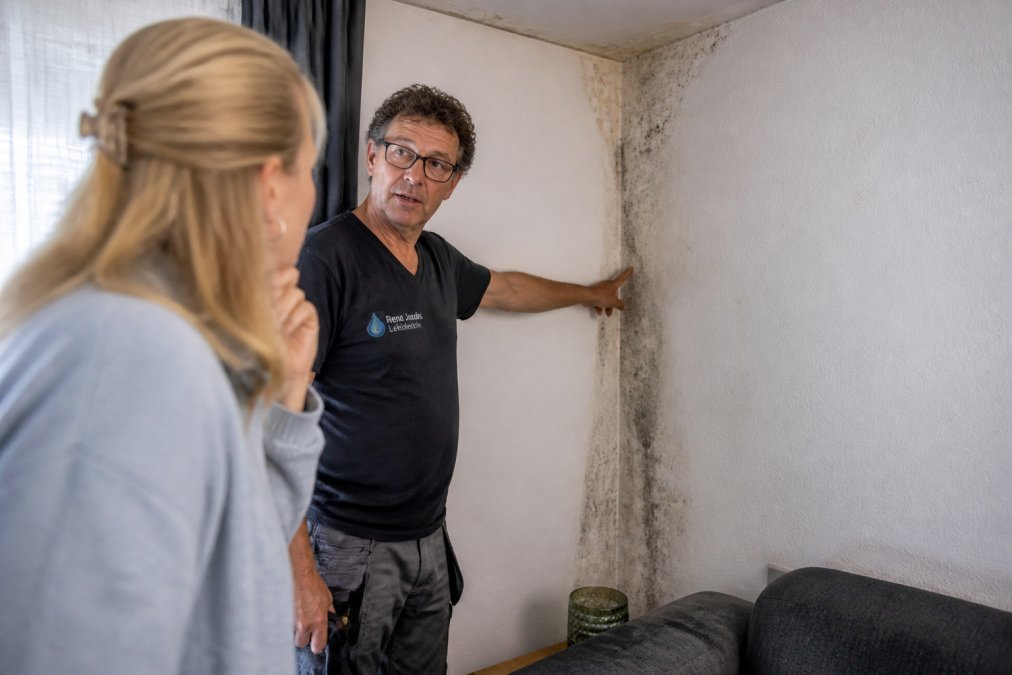 Close-up van vochtplekken en schimmel op een muur door een lekkage die leidt tot een hoge waterrekening lekkage in huis.