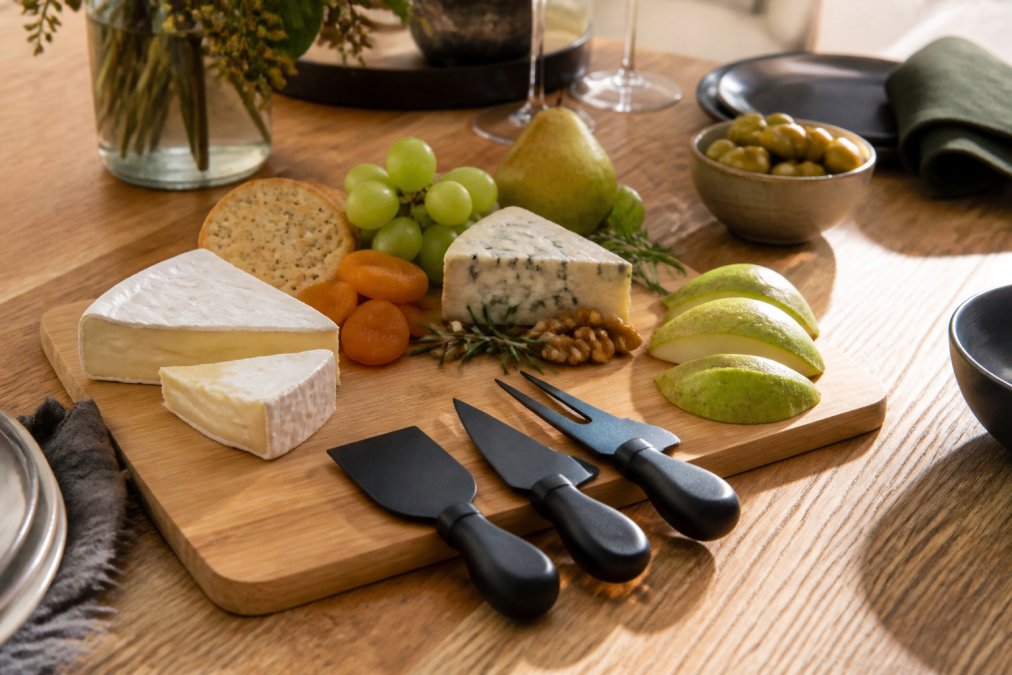Infographic showing a step-by-step guide to styling housewarming party gifts like bamboo cheeseboards and cheese knives.