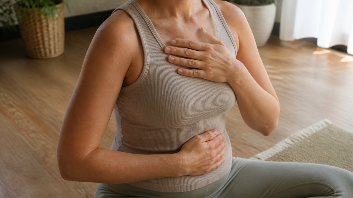 Person practicing diaphragmatic breathing for physiological treatments for nervous system regulation in a calm room