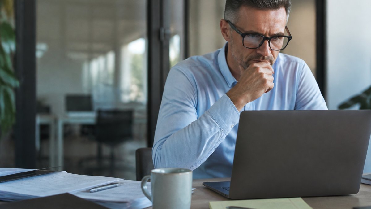 Concerned professional reviewing data brokers find information on a laptop screen at a desk
