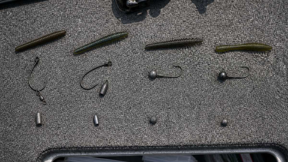 Overhead flat-lay of four finesse rigs, drop shot, Texas rig, shaky head, and Ned rig, laid out on a boat deck with corresponding hooks and weights labeled
