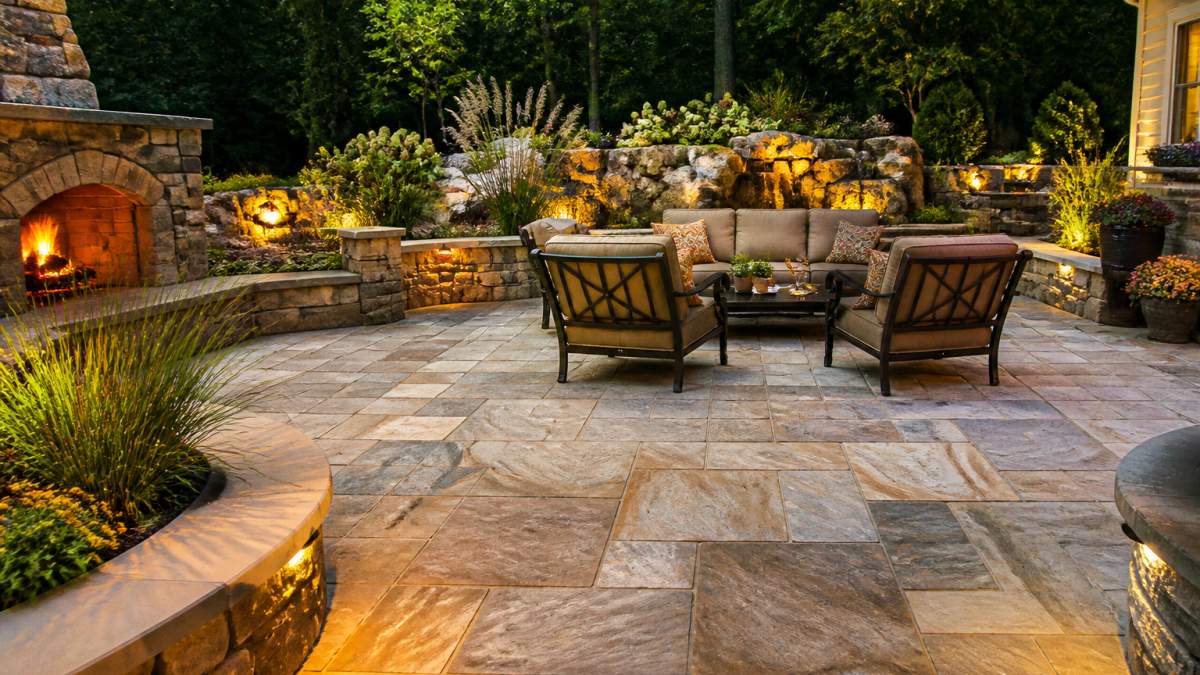 Luxury patio featuring integrated masonry luxury landscape design with natural stone textures and evening lighting.