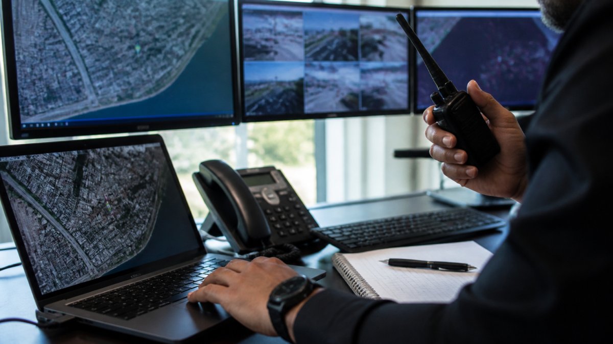 Security professional monitoring real-time data for executive protection travel at a command center desk