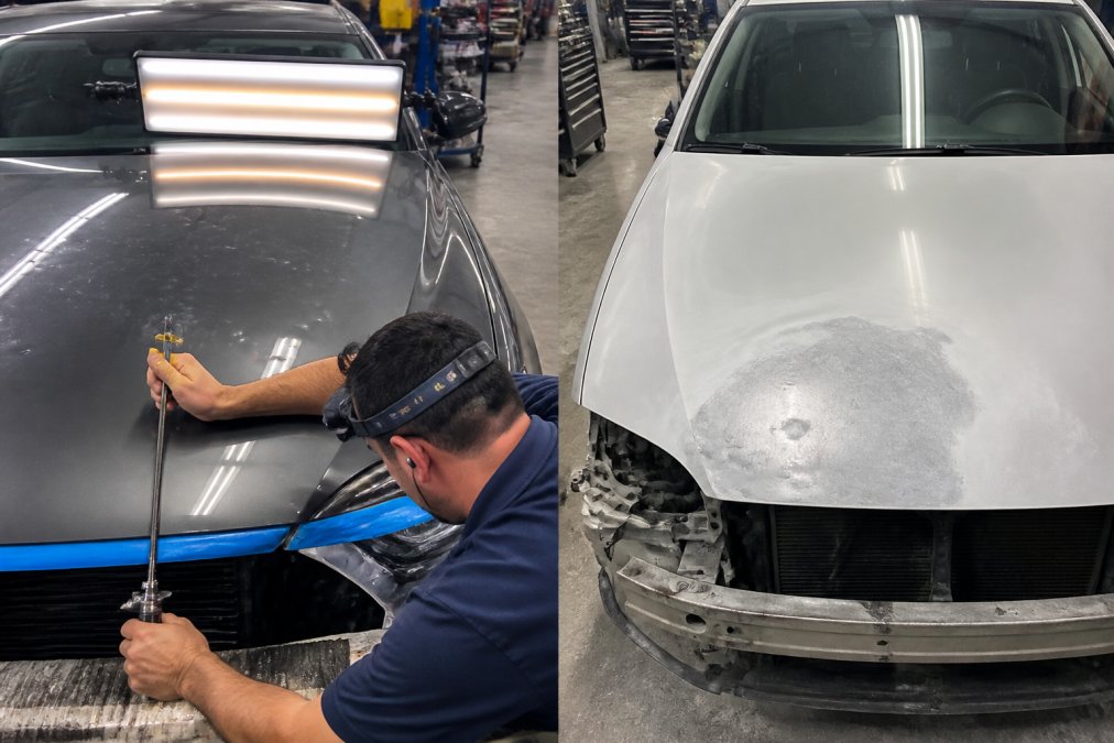 Professional technician using specialized metal-working tools to perform paintless dent repair on a vehicle hood, carefully manipulating the panel from behind while monitoring progress from multiple angles in a well-lit workshop