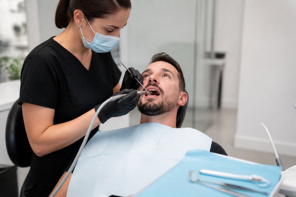 Dental hygienist performing professional dental cleanings on a patient in a bright, modern clinic